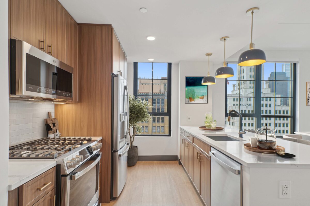 Sleek kitchen with wood cabinetry, island seating, and skyline view.