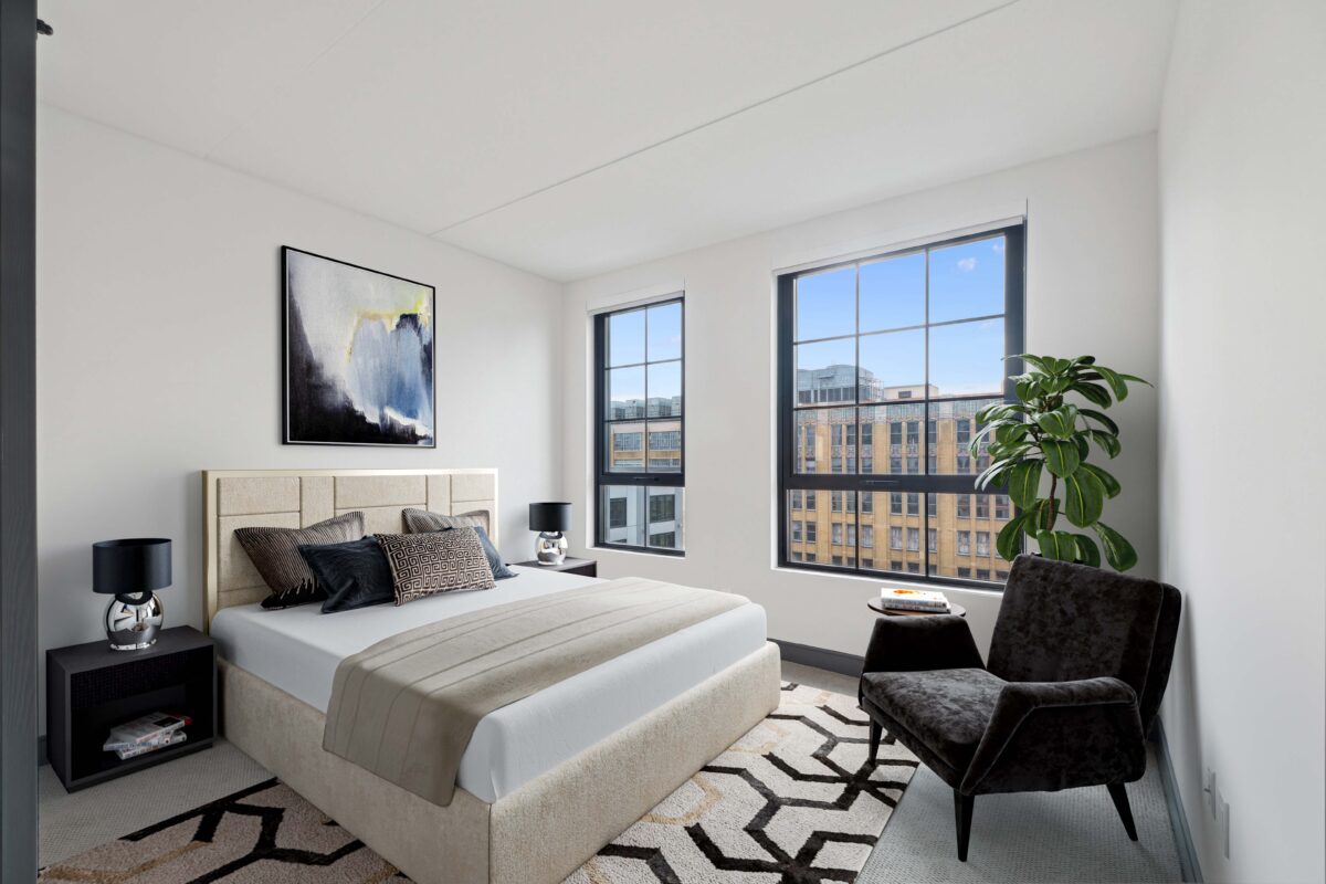Contemporary bedroom with upholstered bed and large city-view windows