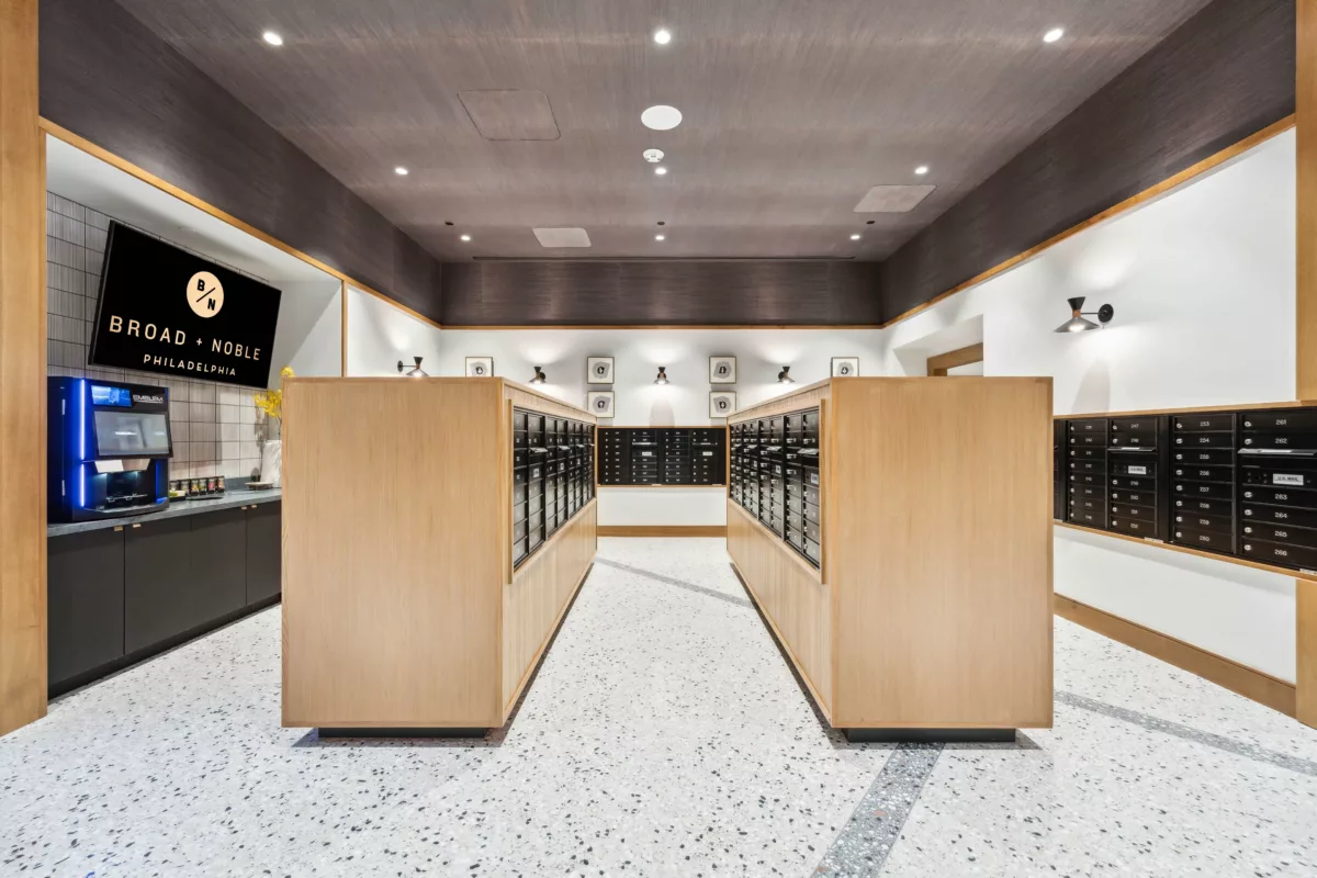 Mail room with black mailboxes, marble floor, and coffee bar and TV screen