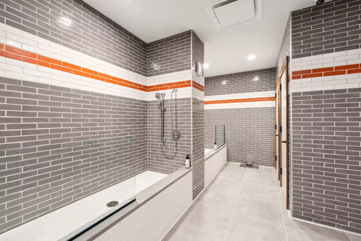 Pet spa with gray tiles walls and cleaning areas and showers
